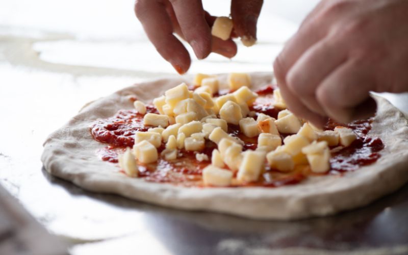 pizza base with diced mozzarella cheese